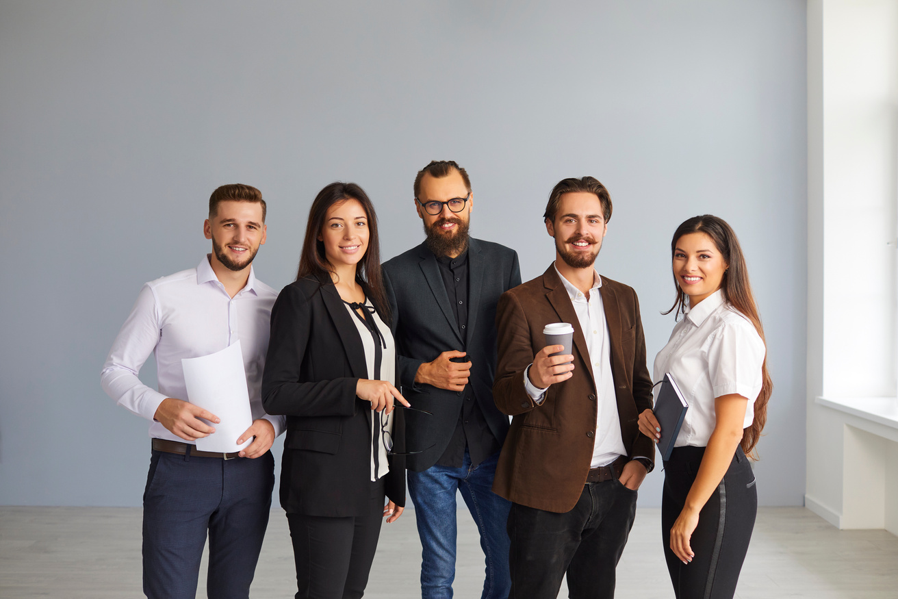 Group of Happy Young Office Employees or Startuppers Standing Together Looking at Camera